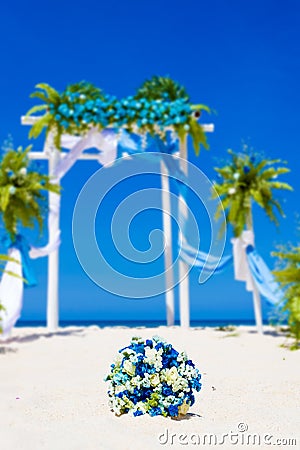 Wedding arch decorated with flowers on tropical sand beach, outd