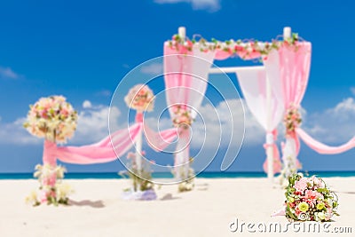 Wedding arch decorated with flowers on tropical sand beach, outd