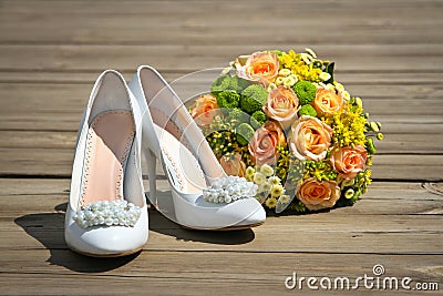 Wedding bouquet & shoes on a wooden platform