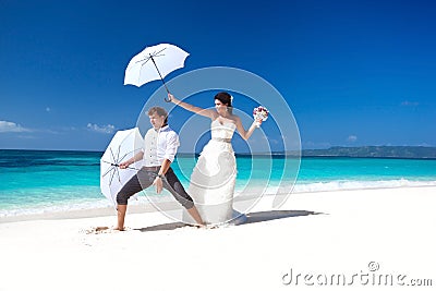 Wedding couple on beach having fun