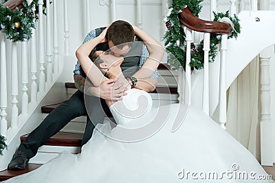 Wedding pair, kiss on stairs. Veil. Indoor