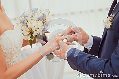 Wedding rings being exchanged during ceremony.