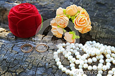 Wedding rings, boutonniere and a string of pearls