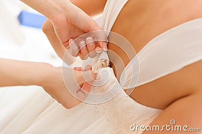 Weddings preparation, zipping-up white dress.