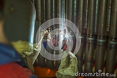 Welder welding metal pipes