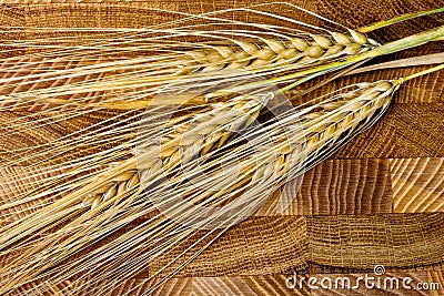 Wheat Ears on the Wooden Table. Sheaf of Wheat over Wood Backgro