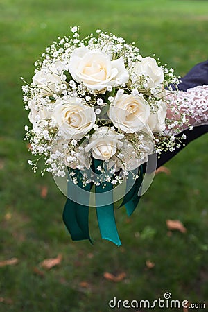 White bouquet in the hands of the bride