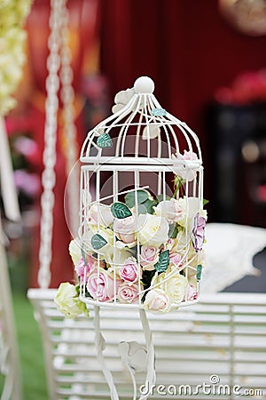 White cage with natural roses as decoration