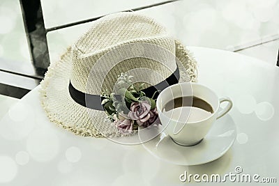 White cup of hot tea and Straw Hat with vintage style