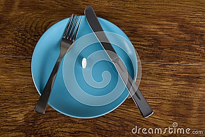 White diet pill on plate weight loss and anorexia concept