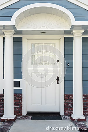 White front door of classical blue and brick home