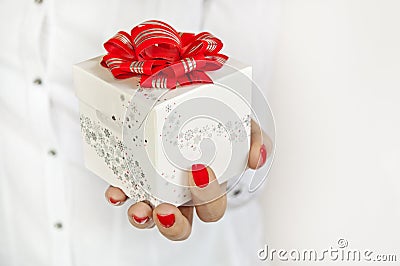 White gift with red ribbon in woman s hand