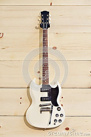 White guitar on wood grain wall