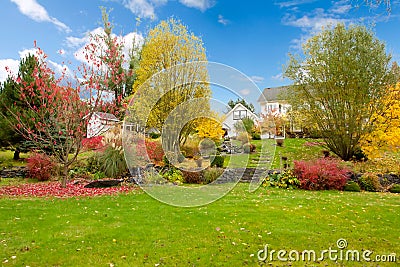 White horse farm American house during fall with green grass.