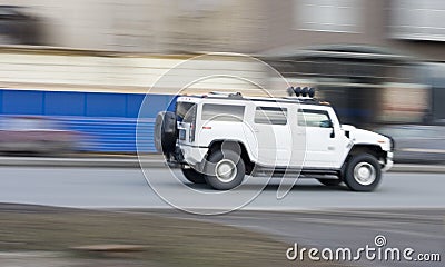 White huge hummer suv car driving fast, rushing forward