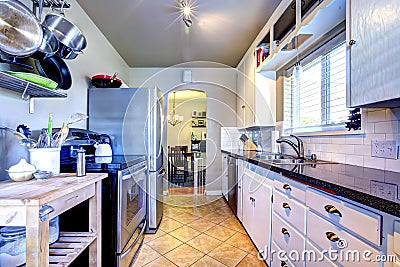 White kitchen with grey walls and pots and pens.