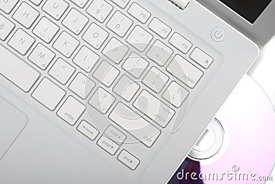 White laptop with dvd disk in slot. Isolated.