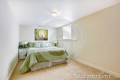 White large bedroom with green bed and art.