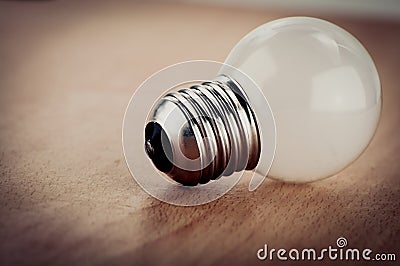 White light bulb on wooden background vintage style