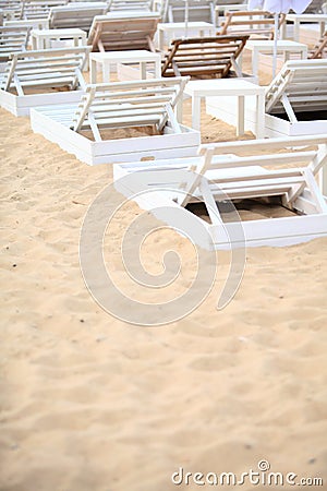 White pool chairs on sand beach