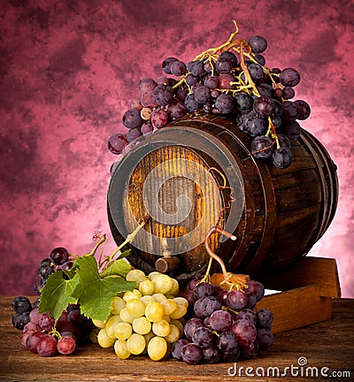 White and red grapes with wine barrel