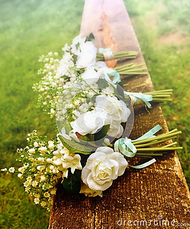 White roses on a bench before a country wedding