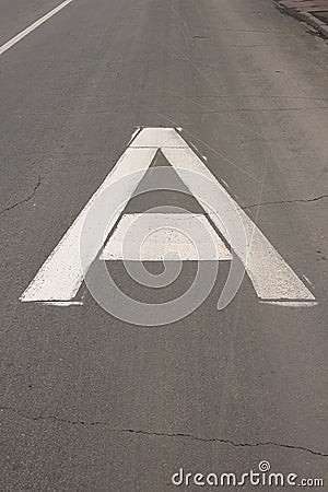 The white sign on the road “Bus lane” in the form of a big capital letter A