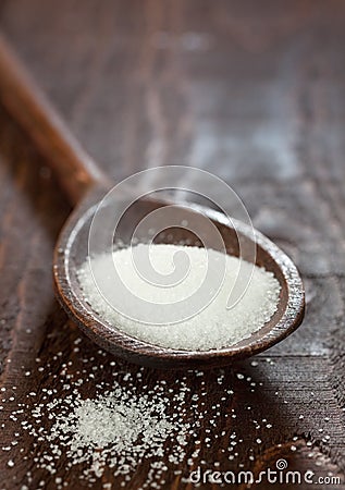 White sugar on wooden spoon