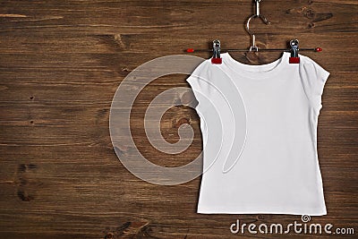 White T-shirt hanging on wooden background