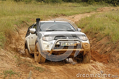 White Toyota Triton DHD crossing mud obstacle
