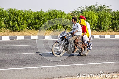 Whole indian family on a scooter on the road