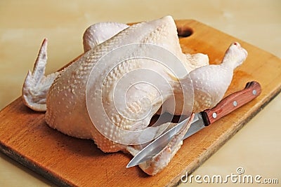 Whole raw chicken on the chopping board