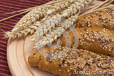 Wholemeal bread with wheat ears on the table.