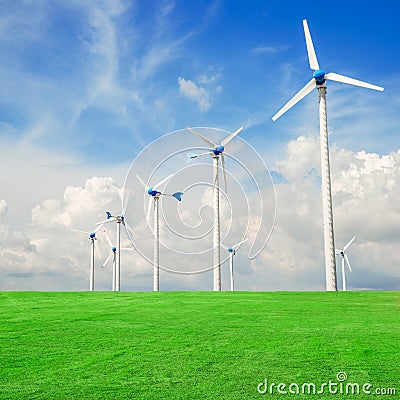 Wind mill power plant in green field against blue sky
