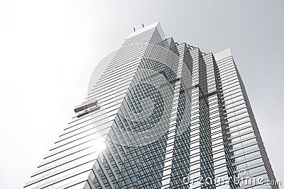 Window cleaners working on sunlit glass skyscraper