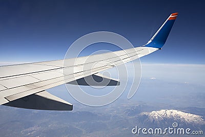 Wing of the plane on blue sky.