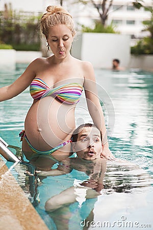 Woman against her husband jumping into the pool