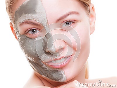 Woman applying clay mask on face. Spa.