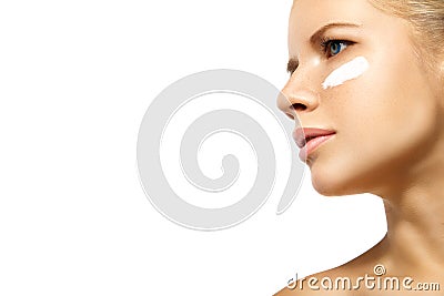 Woman applying moisturizer cream on face isolated