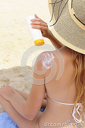 Woman applying sunscreen lotion at the beach