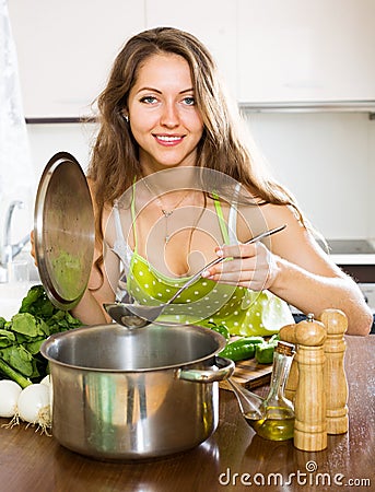 Woman in apron cooking soup