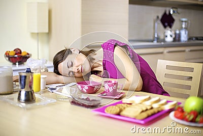 Woman asleep on kitchen table during breakfast