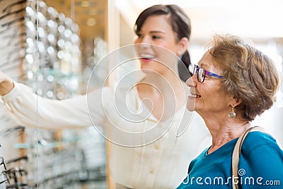 Woman Assisting Senior Customer In Selecting