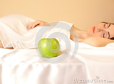 Woman in bed with apple (focus on apple)