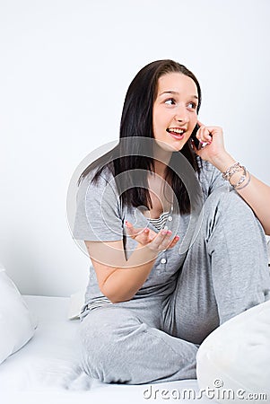 Woman on bed having conversation by phone