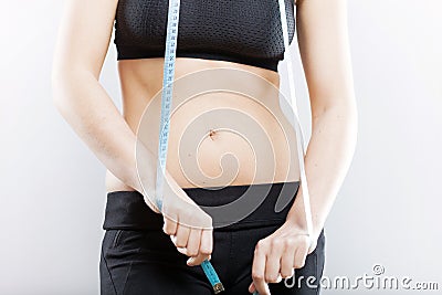 Woman belly and measuring tape, weight loss concept