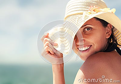 Woman in big summer hat on the sea coast