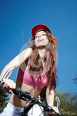 Woman biking under blue sky