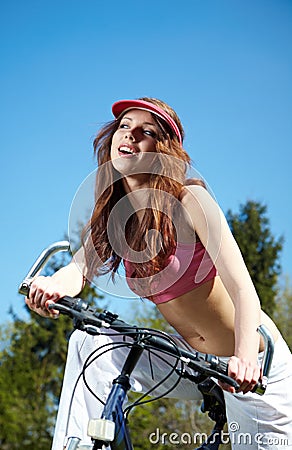 Woman biking under blue sky