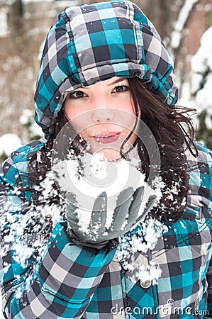 Woman blowing snow at winter